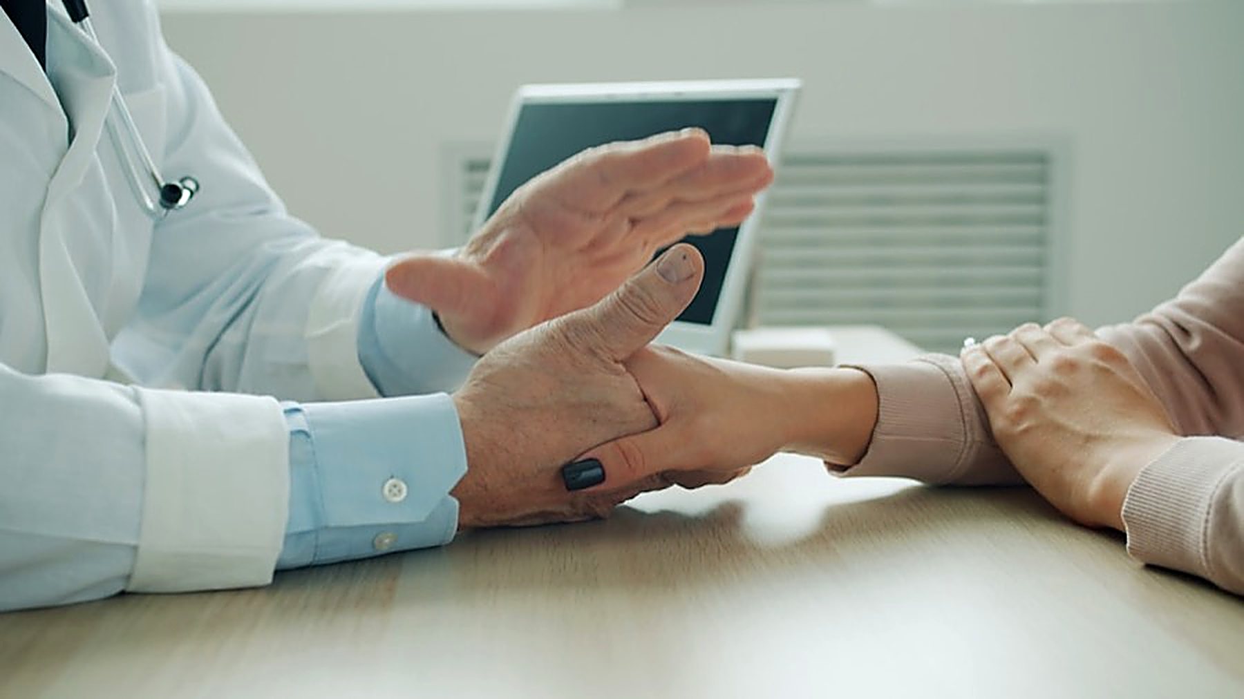 Les mains d'un médecin, ouvertes, face à celles d'un patient.